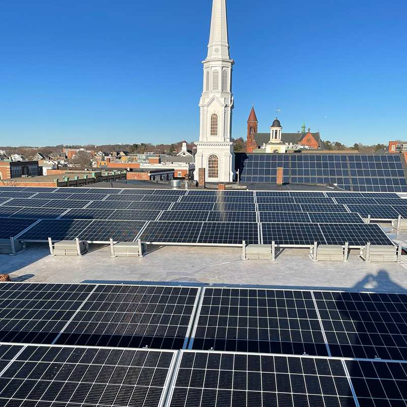 Rows of Rooftop Solar Panels Installed on a Municipal Property Under Clear Skies in Beverly, MA
