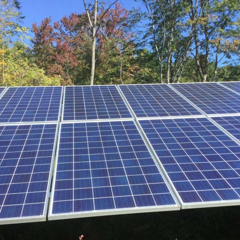 Photovoltaic Solar Panels Are Being Mounted on a Roof near a Wooded Landscape in Athol, MA