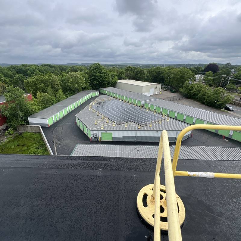 Solar Array Installed on the Rooftop of a Self-Storage Facility Surrounded by Trees in Norwood, MA