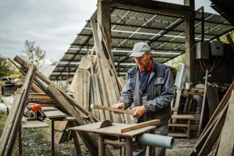 Woodworker using table saw in outdoor shop with solar panels in New England & Beyond