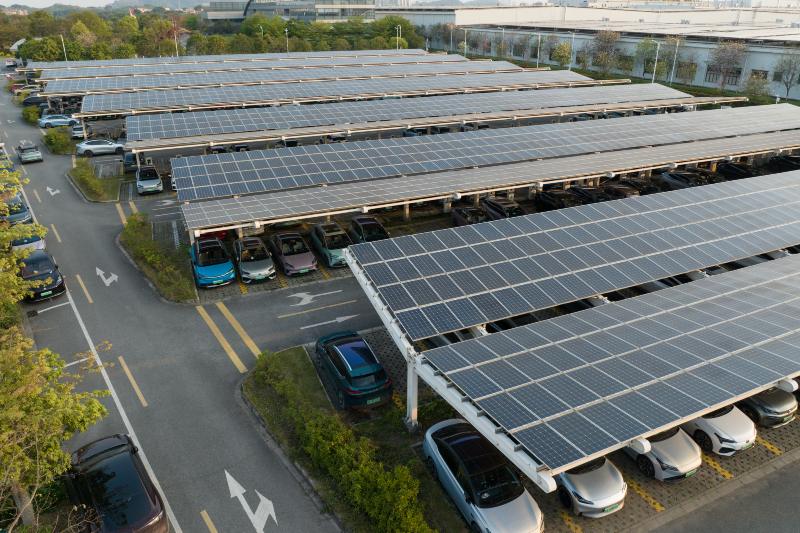Solar carport covering parking lot with vehicles in New England & Beyond