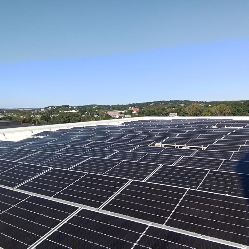 Rows of Photovoltaic Solar Panels Installed Across a Large Commercial Rooftop in Watertown, MA