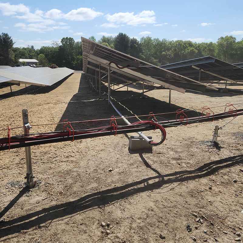 Utility-Scale Solar Installation with Ground-Mounted Panels and Electrical Cabling in Hopkinton, MA